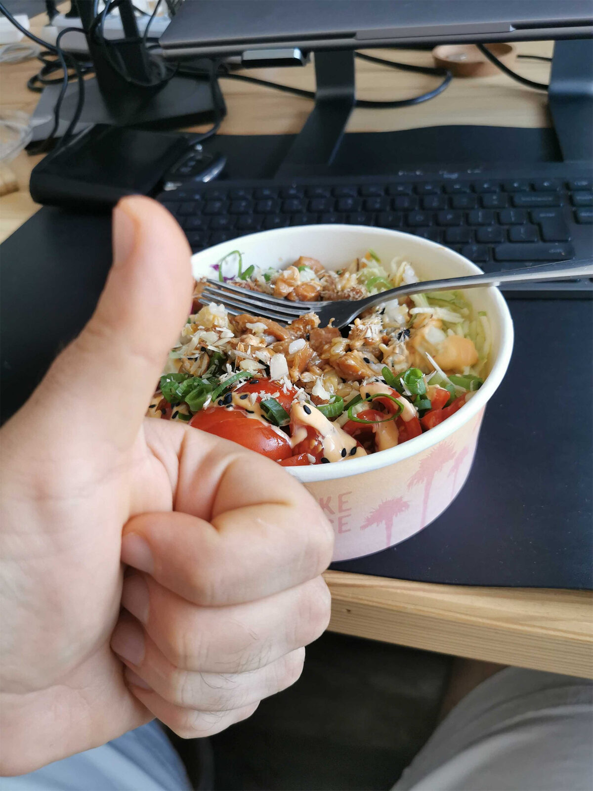 A thumbs-up over a poke bowl at the desk