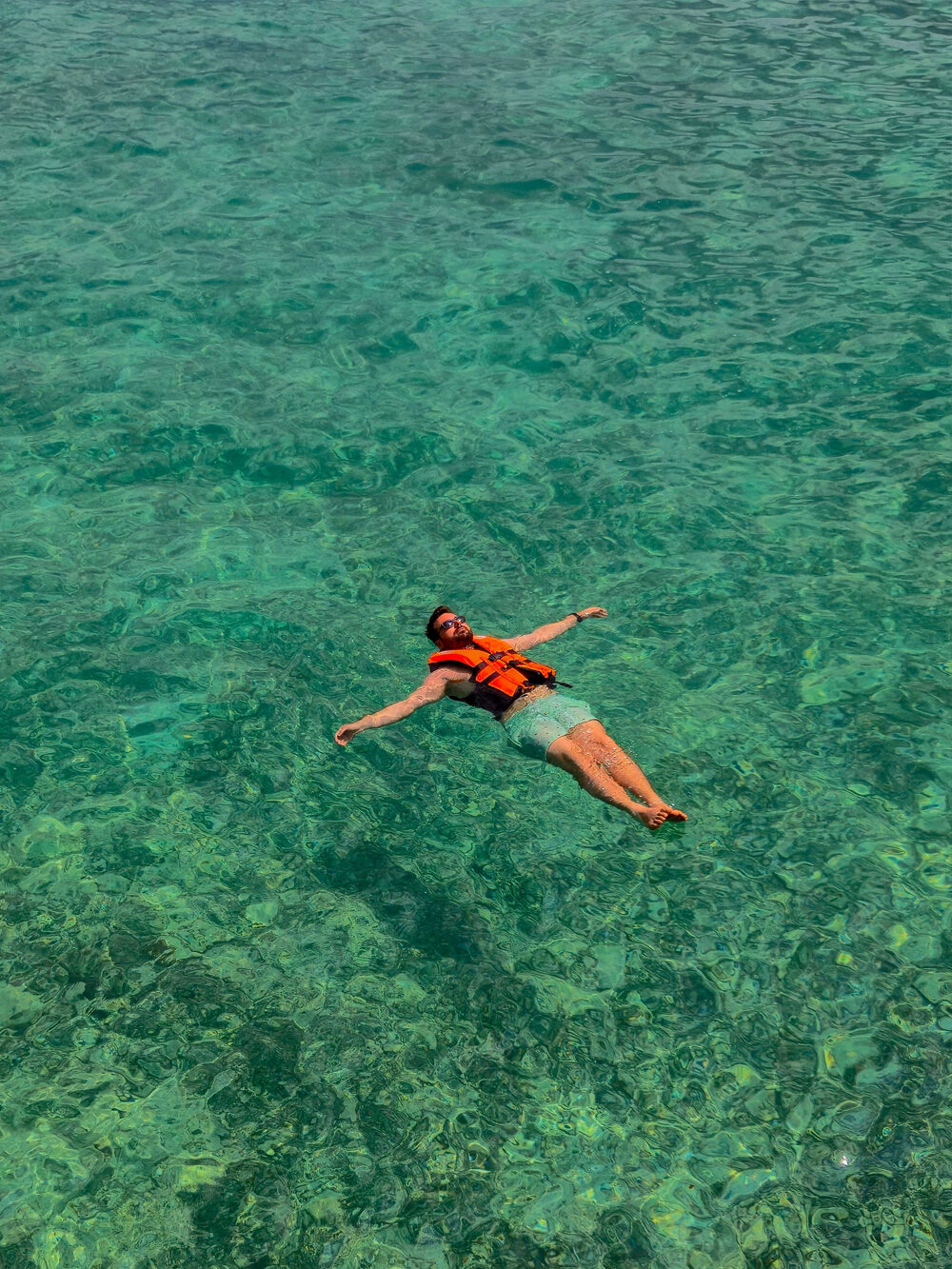 One of the team floating on his back in clear open water